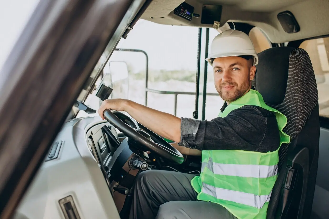 Ein männlicher Arbeiter mit einem Bulldozer in einer Sandgrube.